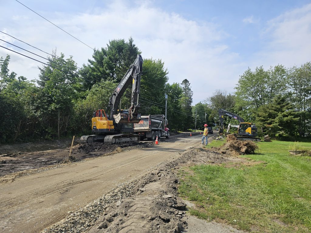 Excavator truck on a dirt road in summer digging
