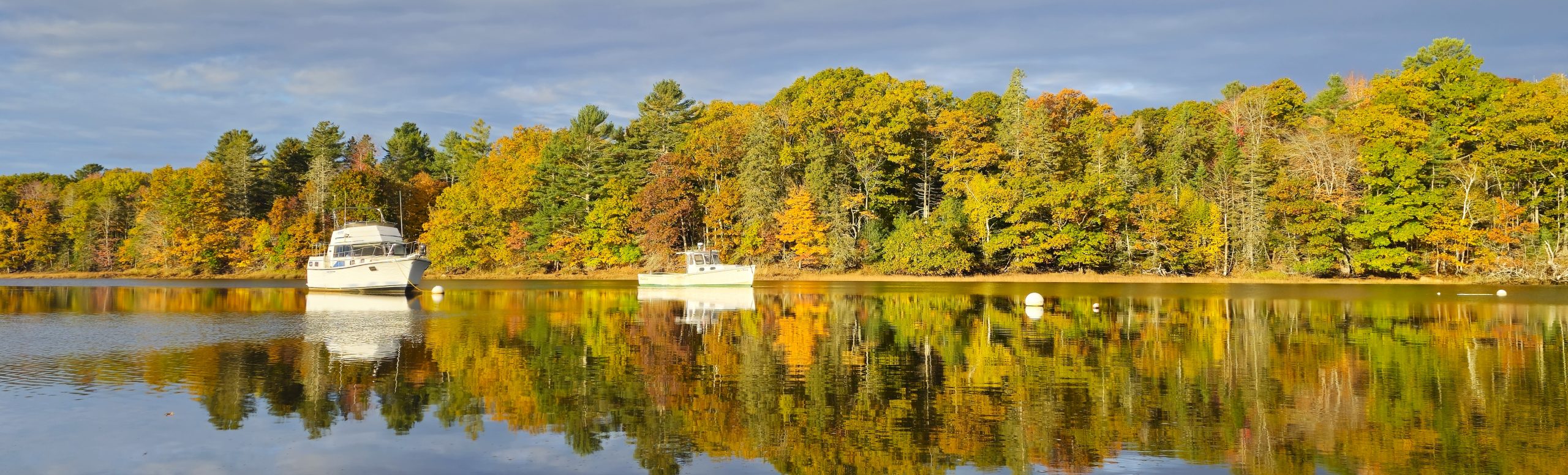 Image of boats in the Union River from the dock of the Harbor Park and Marina