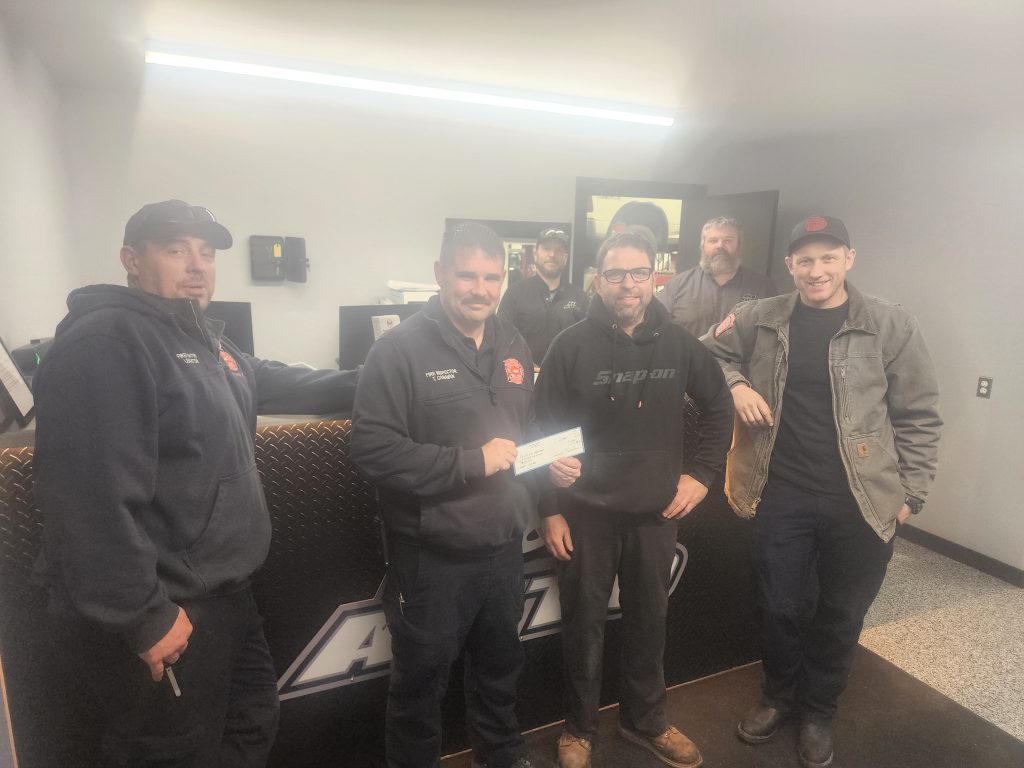 Photo of K&B Automotive presenting a check to the Fire Department
