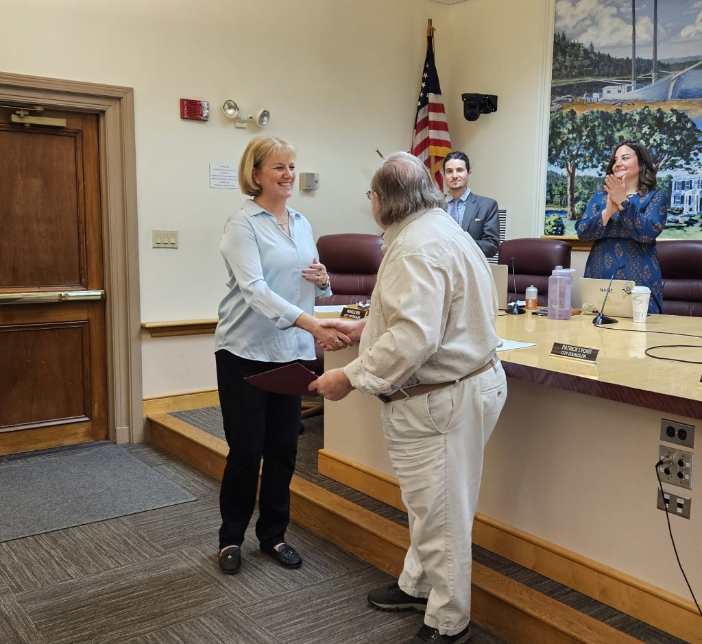Larry shaking hands with Michelle Beal and receiving certificate.